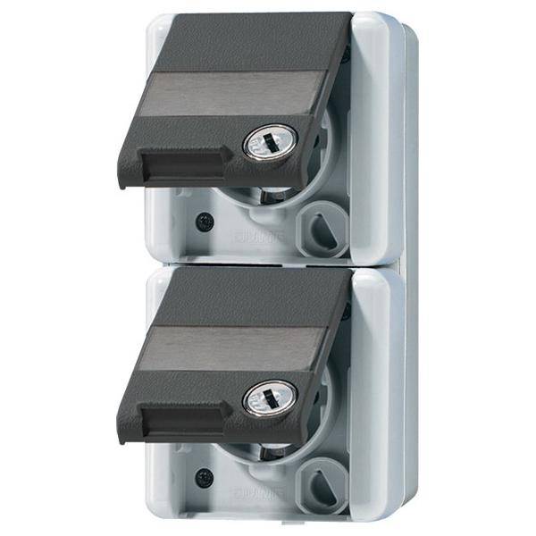 Zwei überkappte elektrische Steckdosen mit Schutzdeckel und Schloss, senkrecht montiert. Das Design gewährleistet Sicherheit und verhindert unbefugten Zugang.