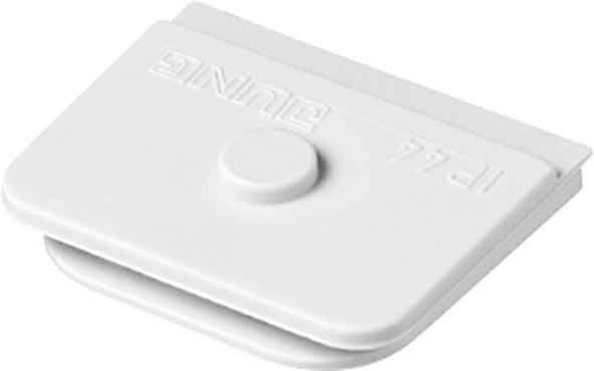 Eine weiße Plastikkappe mit dem Wort 'Dune', das in sie eingeprägt ist. Sie verfügt über einen erhabenen zentralen kreisförmigen Knopf und scheint zum Versiegeln konzipiert zu sein.