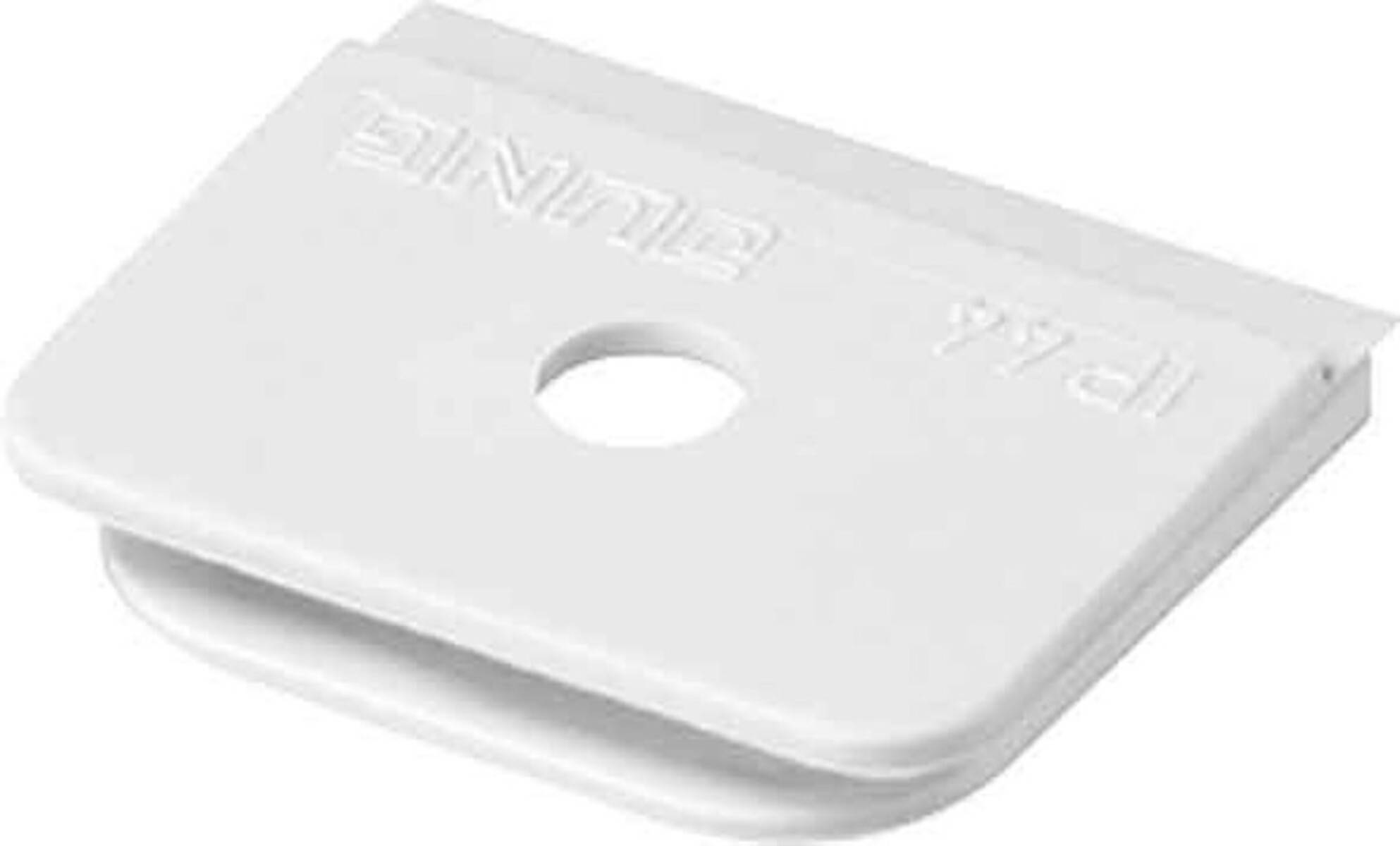 Ein weißes Plastikgerät mit einem zentralen Loch, das mit geprägtem Text auf seiner Oberfläche versehen ist.