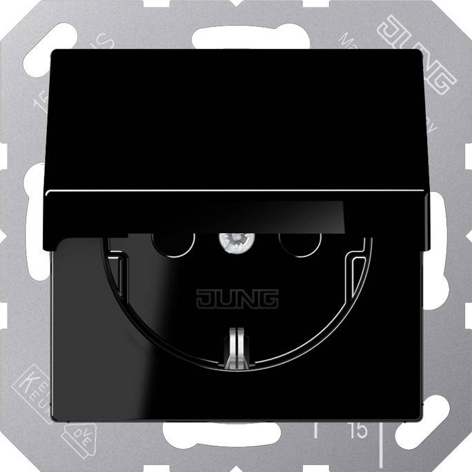 Eine schwarze elektrische Wandsteckdose mit Abdeckung, der Markenname 'JUNG' ist sichtbar, eingebaut in einen metallfarbenen Rahmen.