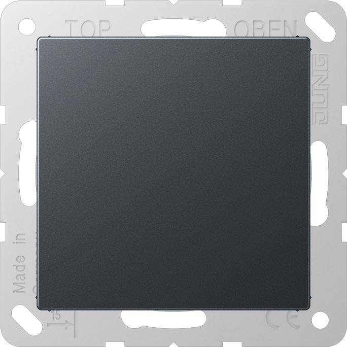 Ein schwarzer quadratischer Elektroschalter mit einem metallfarbenen Rahmen, auf dem links der Text 