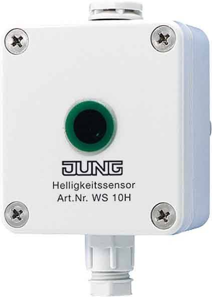 Ein weißer JUNG Helligkeitssensor mit der Bezeichnung 'Helligkeitssensor Art.Nr. 5 10H' mit einem grünen kreisförmigen Sensor in der Mitte und vier Schrauben.