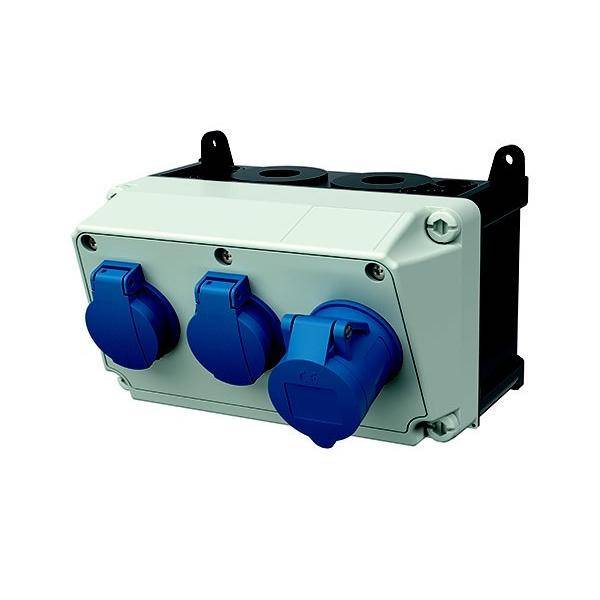 Elektrische Verteilerdose mit drei blauen Steckdosen, an einer weißen Tafel montiert; verwendet für sichere elektrische Geräteverbindungen.