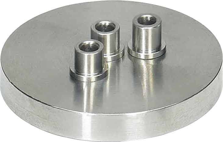 Das Bild zeigt eine runde, metallische Basis mit drei erhöhten zylindrischen Anschlüssen. Die Zylinder sind von gleicher Höhe und gleichmäßig verteilt.