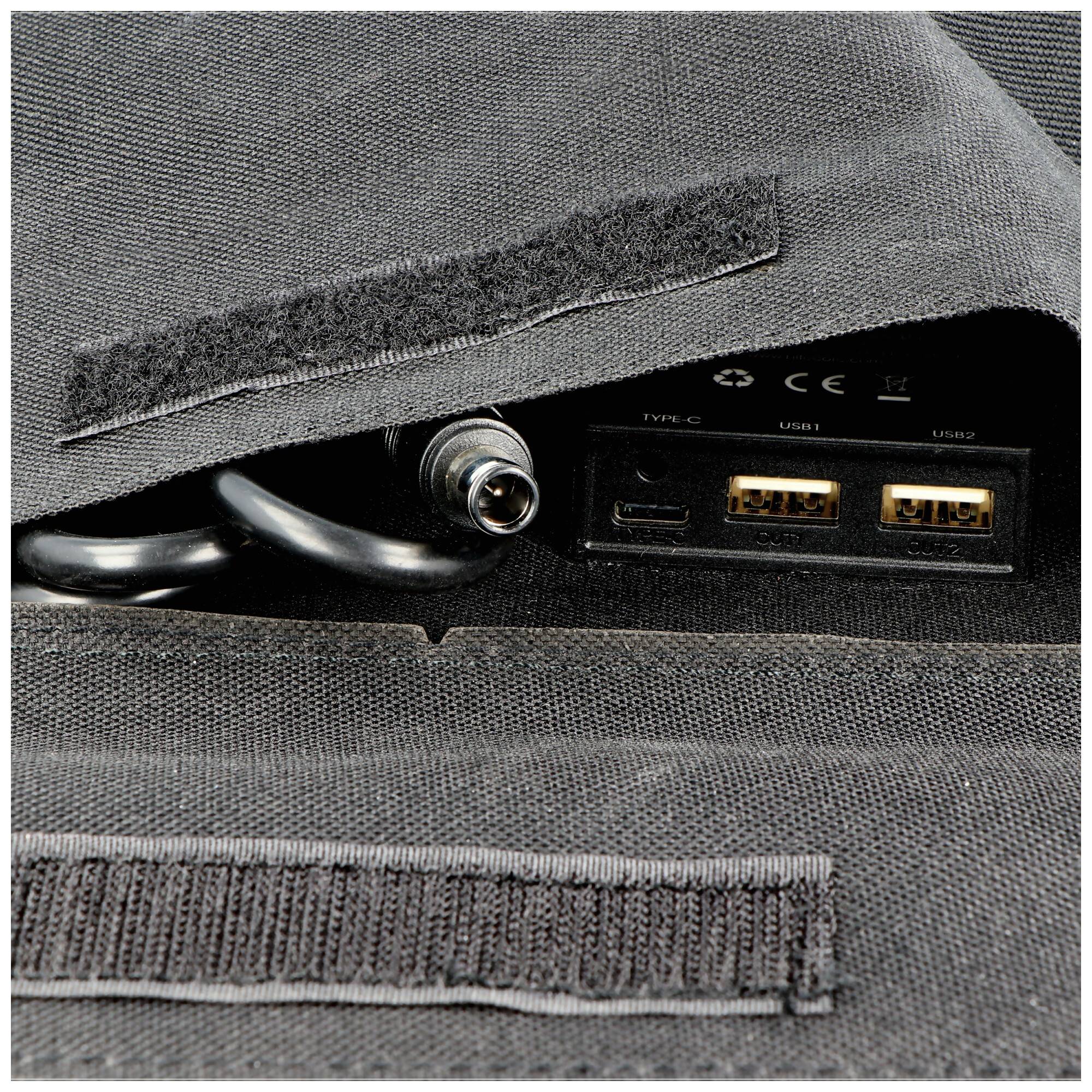 Nahaufnahme einer stoffbezogenen tragbaren Stromversorgungseinheit mit einer Hohlsteckerbuchse und zwei USB-A-Anschlüssen, gekennzeichnet mit Type C, USB1 und USB2.