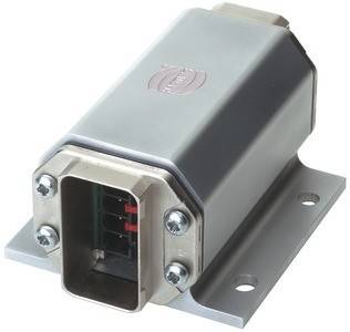 Ein silberfarbenes metallisches rechteckiges elektronisches Gerät mit mehreren Pins in einer offenen Buchse, montiert auf einer flachen Grundplatte mit zwei Schrauben.