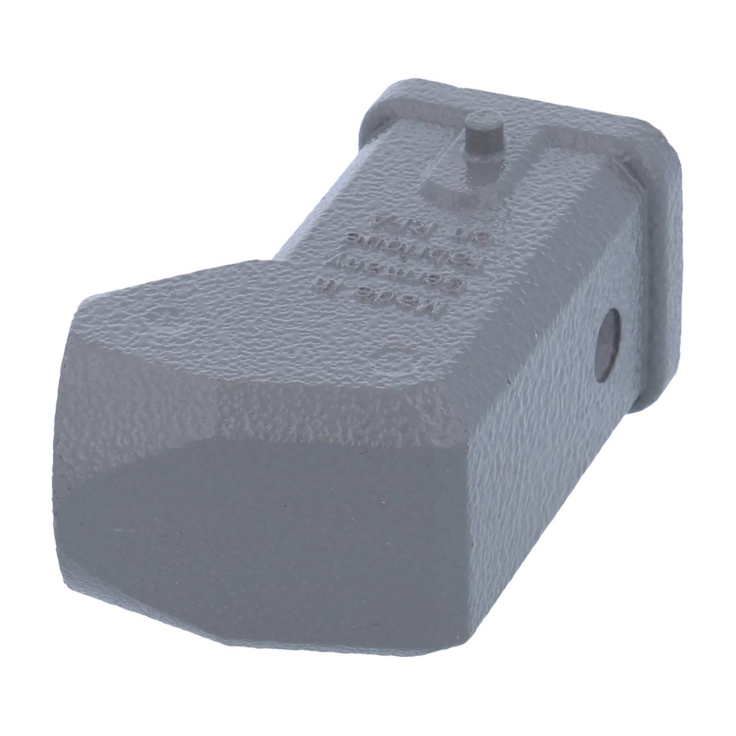 Eine strukturierte, graue, abgewinkelte Metallkomponente mit einer flachen Basis und einer kleinen runden Erhebung oben, möglicherweise Teil einer mechanischen oder industriellen Baugruppe.