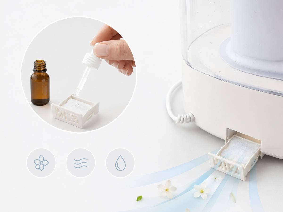 Hand, die ätherische Öltropfen in ein Diffusortablett gibt, mit einem weißen Aromadiffusor, der Nebel freisetzt, und weichen Symbolen, die Duft- und Feuchtigkeitseinstellungen anzeigen.