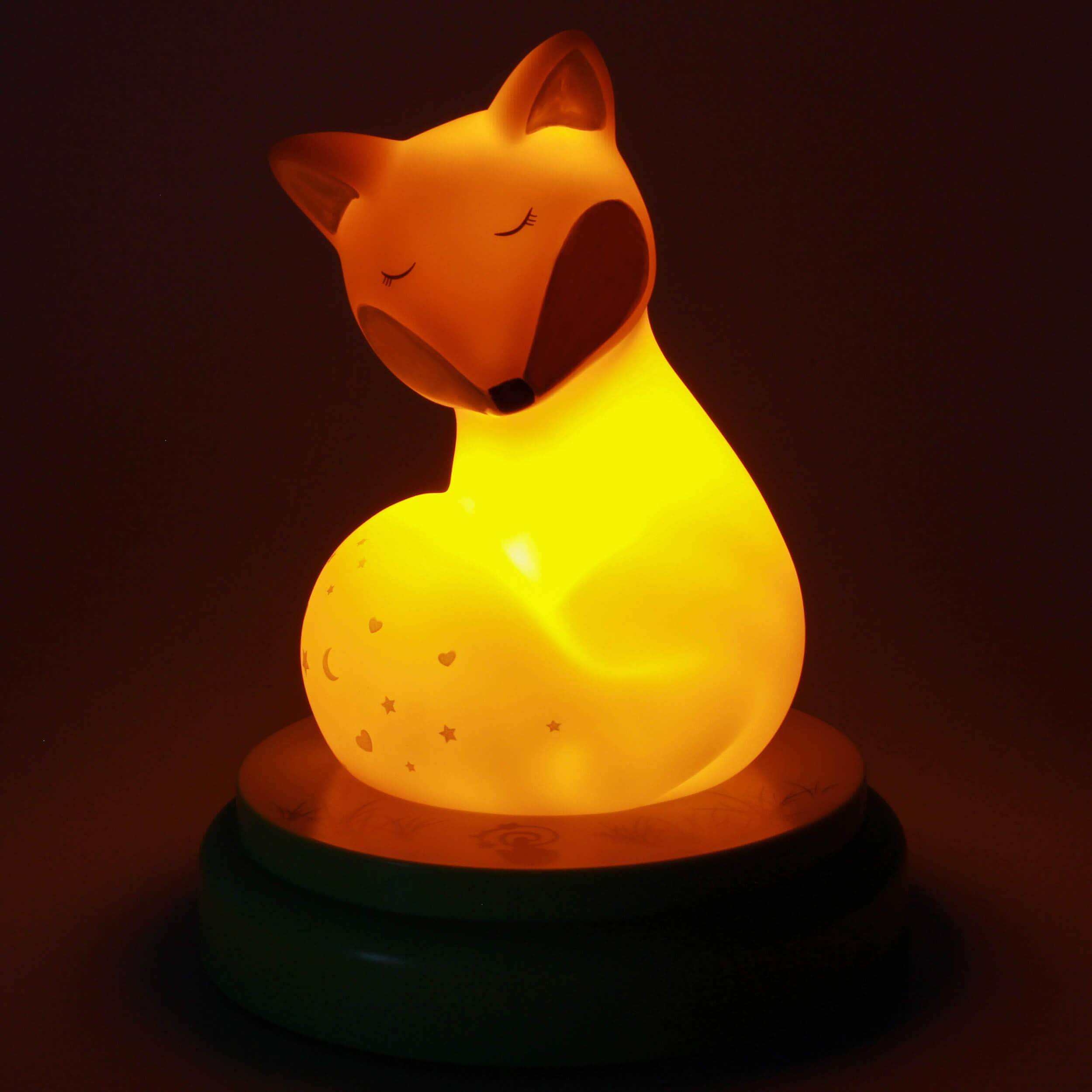Leuchtender fuchs-förmiger Nachtlichter mit geschlossenen Augen, der warmes gelb-oranges Licht auf dunklem Hintergrund wirft.