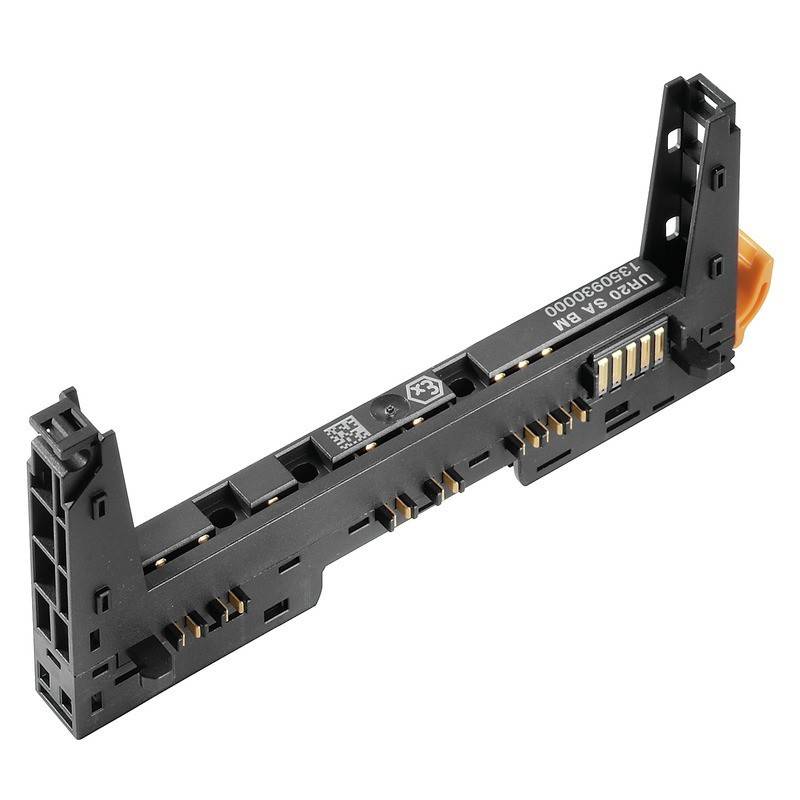 Eine schwarze Elektronikkomponente aus Kunststoff und Metall, möglicherweise ein Verbinder oder eine Befestigungshalterung, mit goldenen Kontakten und einer Seriennummer.
