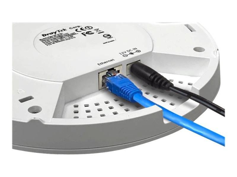 Nahaufnahme der Unterseite eines weißen Netzwerkgeräts mit einem Ethernet-Anschluss, in den ein blaues Kabel eingesteckt ist, und einer Stromversorgungsbuchse mit einem angeschlossenen schwarzen Kabel.