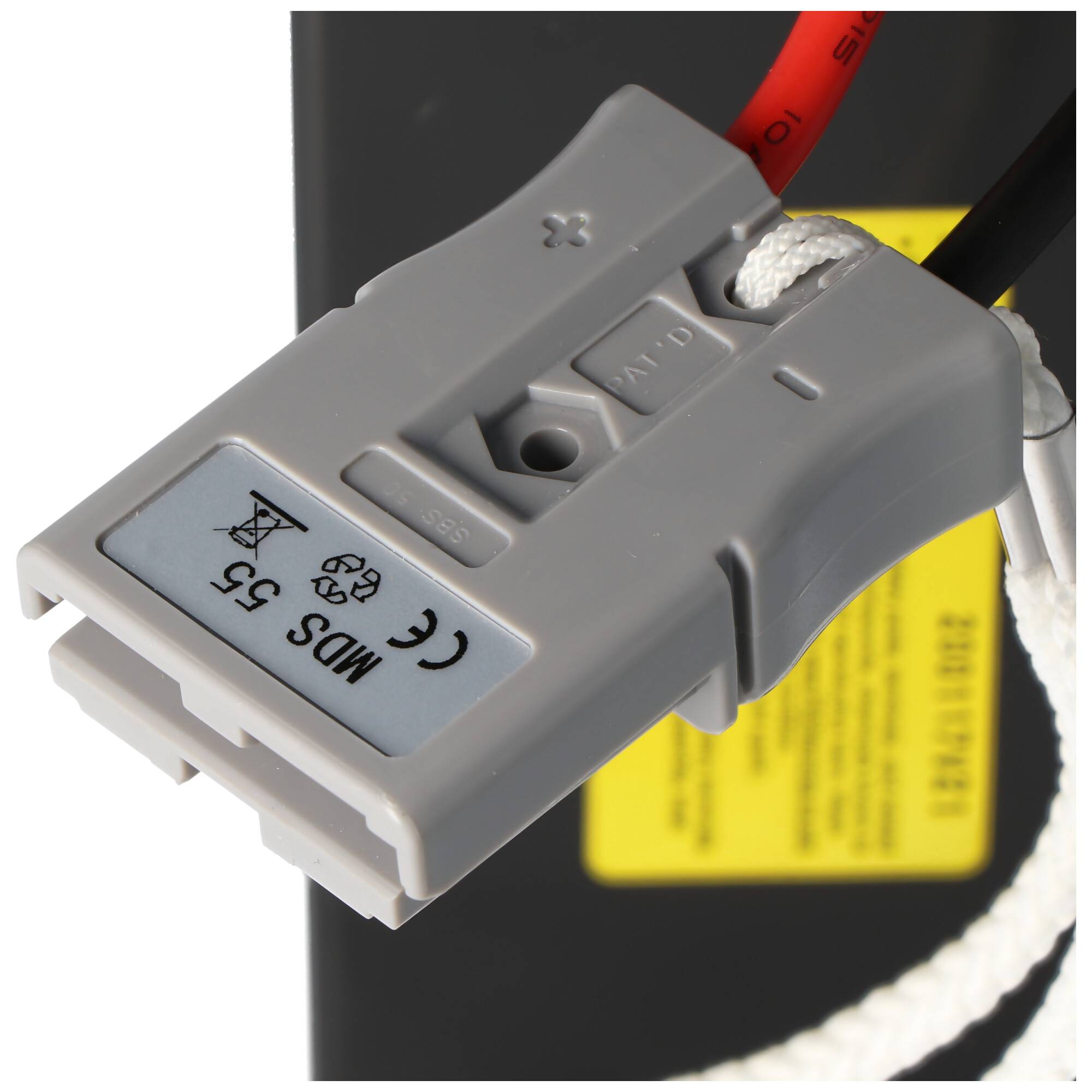 Nahaufnahme eines grauen Elektrosteckers, der in ein Batteriepaket eingesteckt ist, mit roten und schwarzen Kabeln, die angebracht sind.