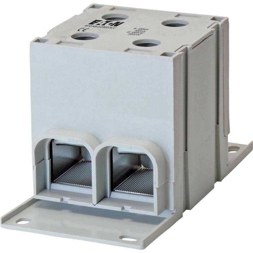 Elektrische Klemmleiste, grau, kubische Form mit vier Öffnungen oben und zwei Drahteinführungspunkten an der Vorderseite zum Anschluss von elektrischen Leitungen.
