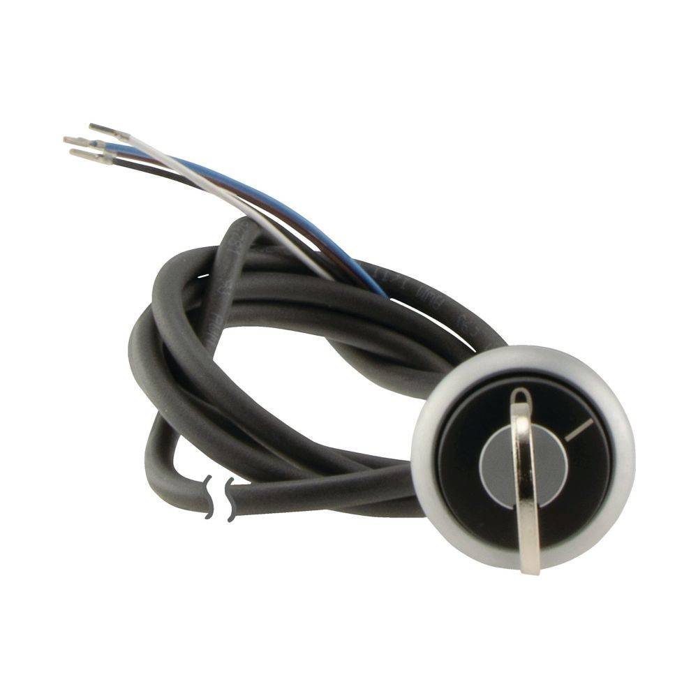 Ein runder, silberner Zündschalter mit drei freiliegenden Kabeln, einem gewundenen Kabel und einem Schlüsselloch in der Mitte, vorgesehen für das Starten von Fahrzeugen oder Maschinen.