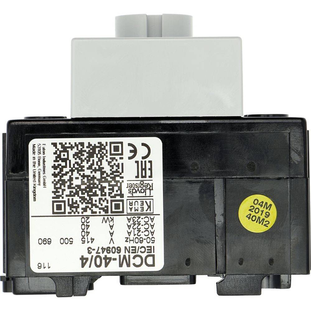 Das Bild zeigt eine elektronische Komponente mit einem QR-Code und verschiedenen Spezifikationen, einschließlich des Modells 'DCM-40/4'. Ein gelber Aufkleber trägt die Aufschrift '04M 2019'.