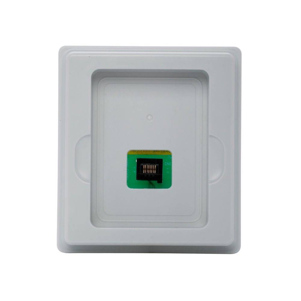 Ein kleiner elektronischer Chip mit metallischen Kontakten ist auf einem grünen Leiterplattenbrett in einem weißen rechteckigen Tablett zentriert.
