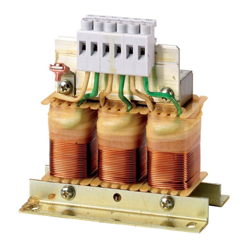 Ein dreiphasiger elektrischer Transformator mit drei Kupferspulen, montiert auf einer Metallbasis und mit einem weißen Anschlussblock als Abschluss.