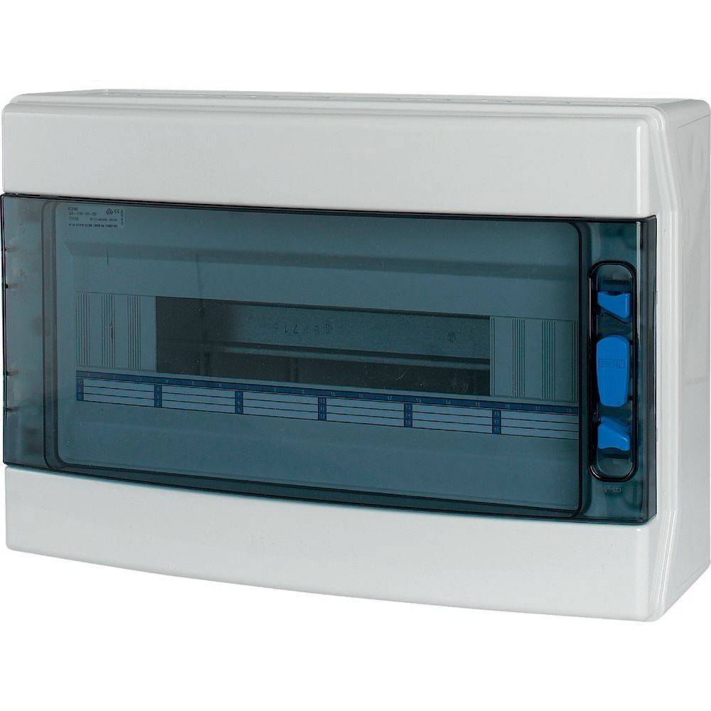 Eine weiße elektrische Verteilerdose mit einem transparenten, blau getönten Deckel, der Steckplätze für Sicherungsautomaten zeigt, an einer Wand montiert.