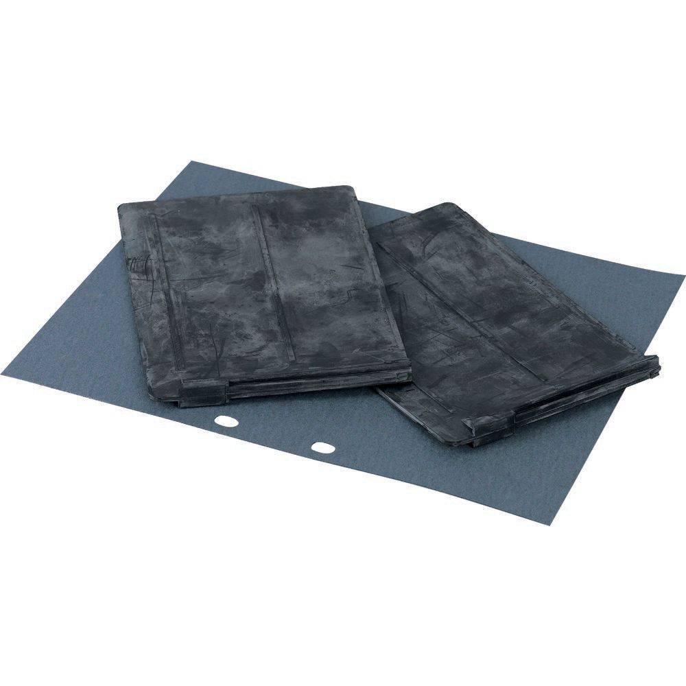 Schwarze Schleifpads auf einem Blatt Schleifpapier, die zum Glätten von Oberflächen bei Bau- oder Holzarbeiten verwendet werden.