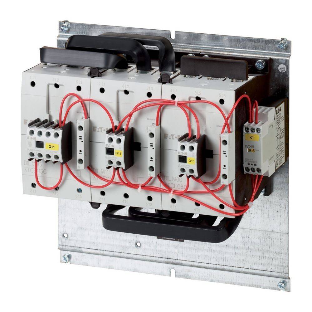 Eine elektrische Verteilerdose mit Sicherungsautomaten und roten Kabeln, montiert auf einer Metallrückwand.