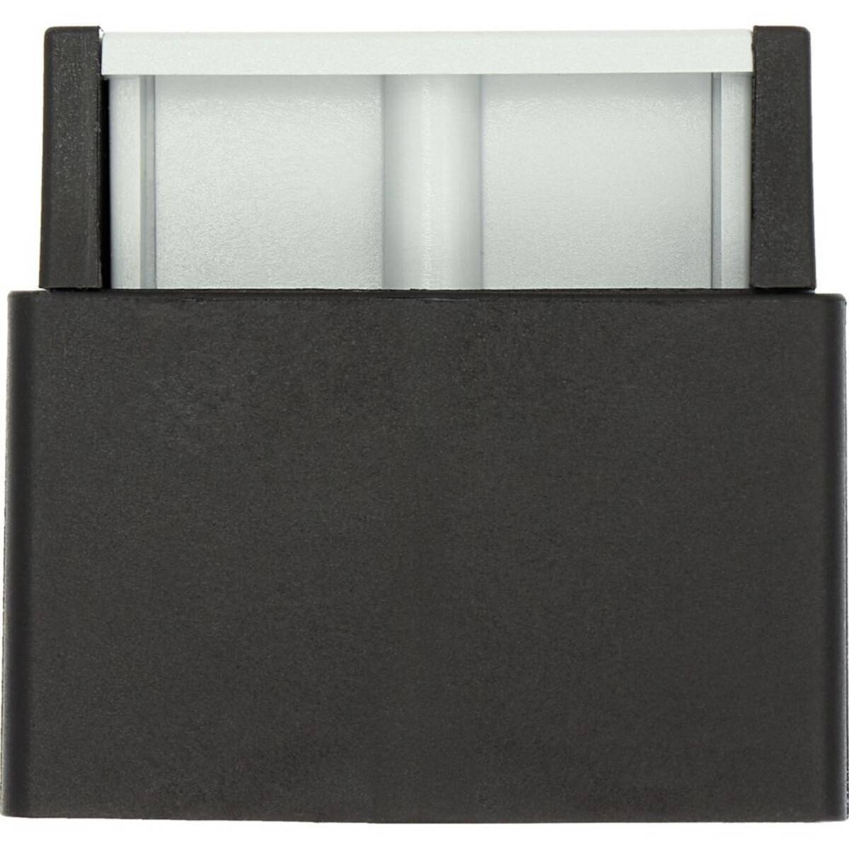 Ein schwarzes rechteckiges Objekt mit einer teilweise an der Oberkante freigelegten grauen Komponente, das einem kleinen elektronischen Adapter oder Stecker ähnelt.