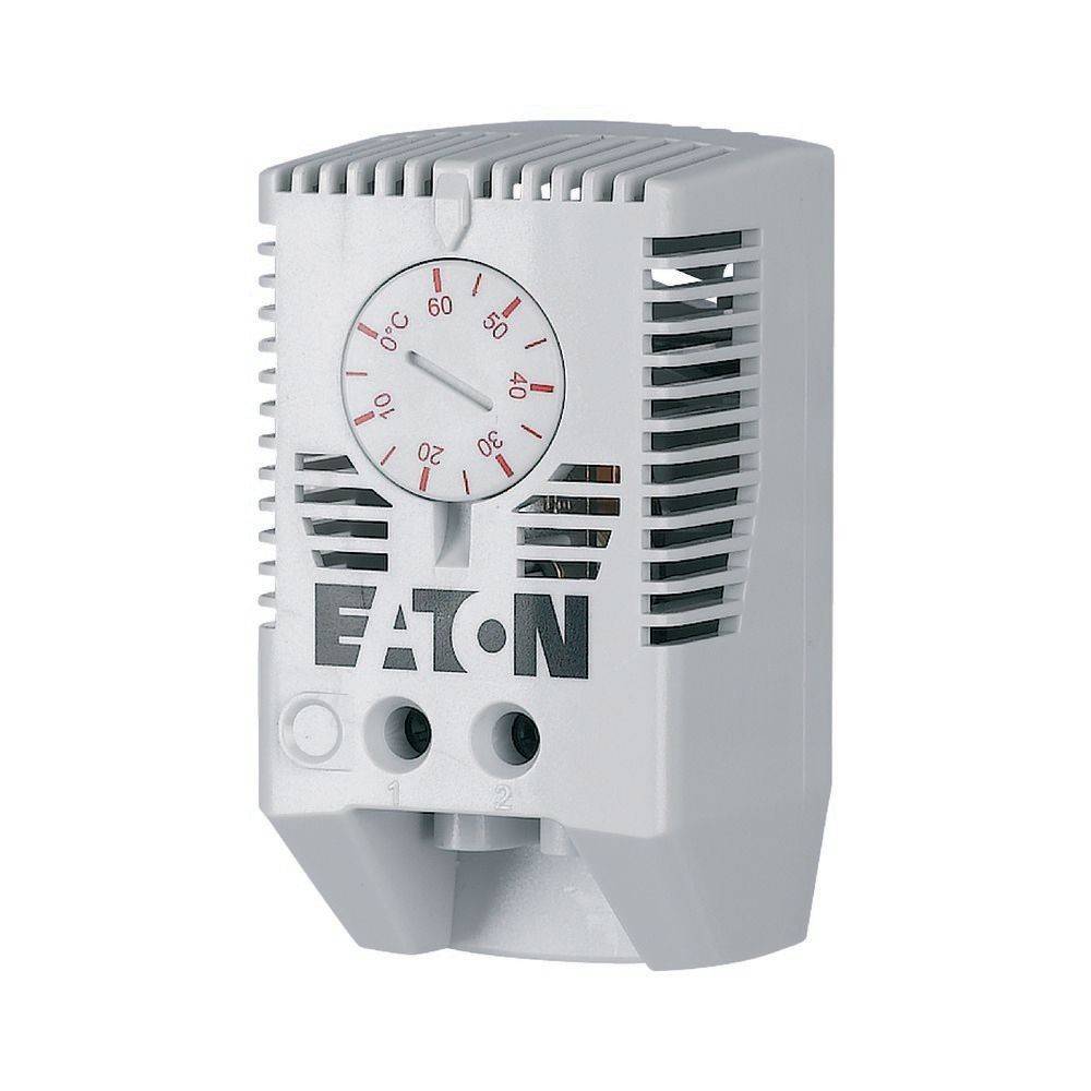 Ein grauer Thermostat mit Lüftungsschlitzen, versehen mit der Markenbezeichnung 'EATON' und einem kreisrunden Zifferblatt, das die Temperatur in Celsius von 0 bis 60 Grad anzeigt.