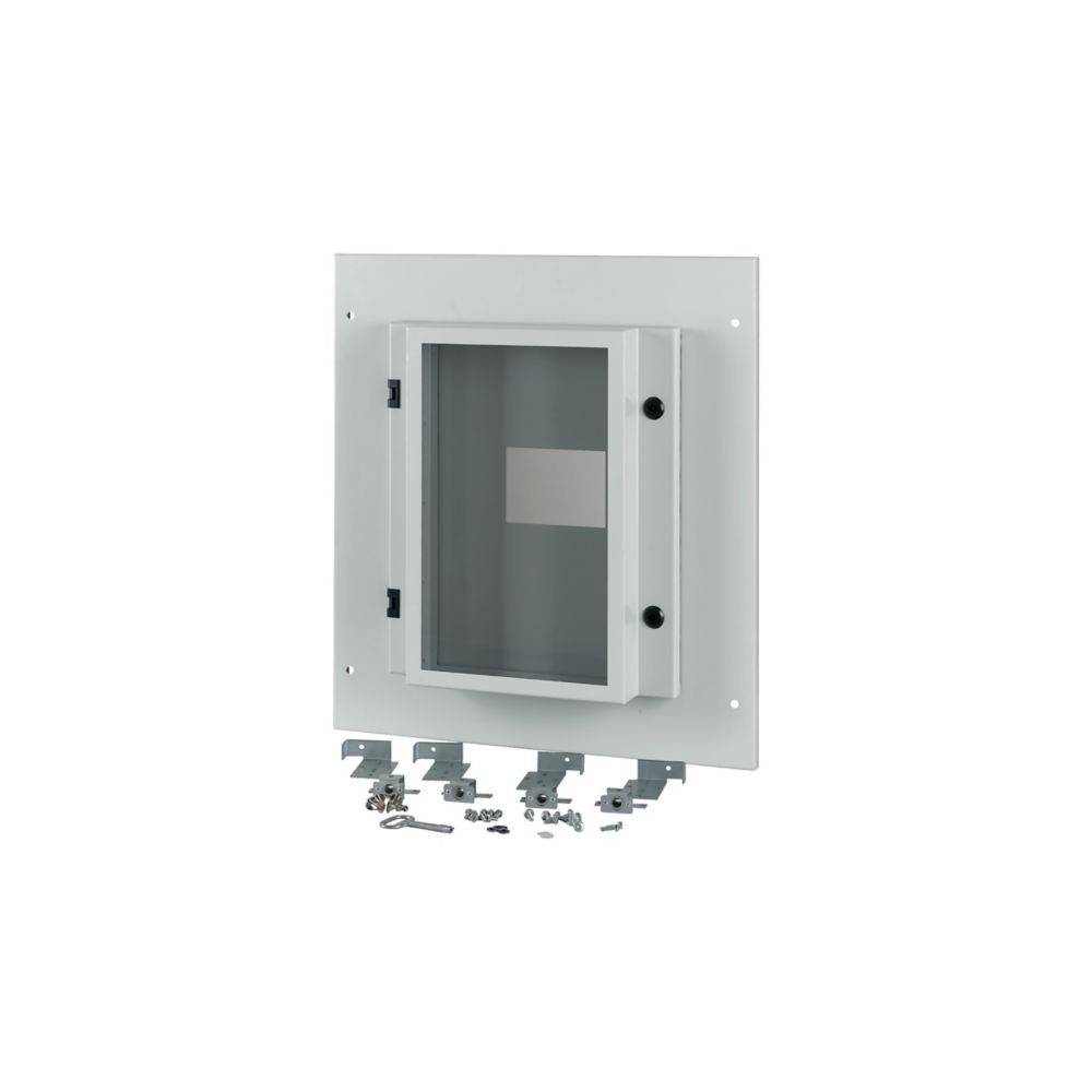 Weißer elektrischer Verteilerschrank mit einer transparenten Tür, an einer weißen Wand montiert. Dazugehörige Schrauben und Halterungen liegen darunter.