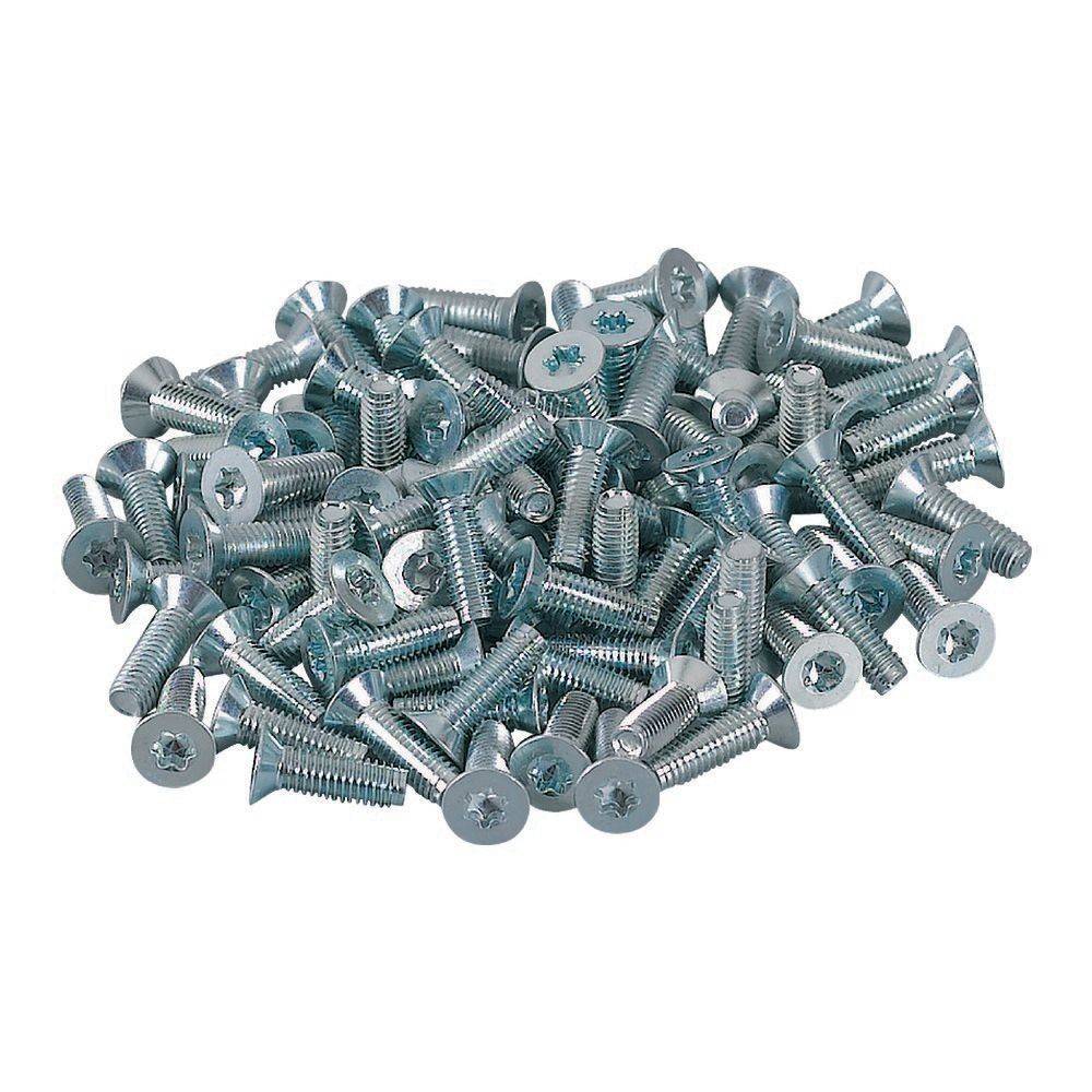 Ein Haufen silberner Metallschrauben, die auf einem weißen Hintergrund verstreut sind.