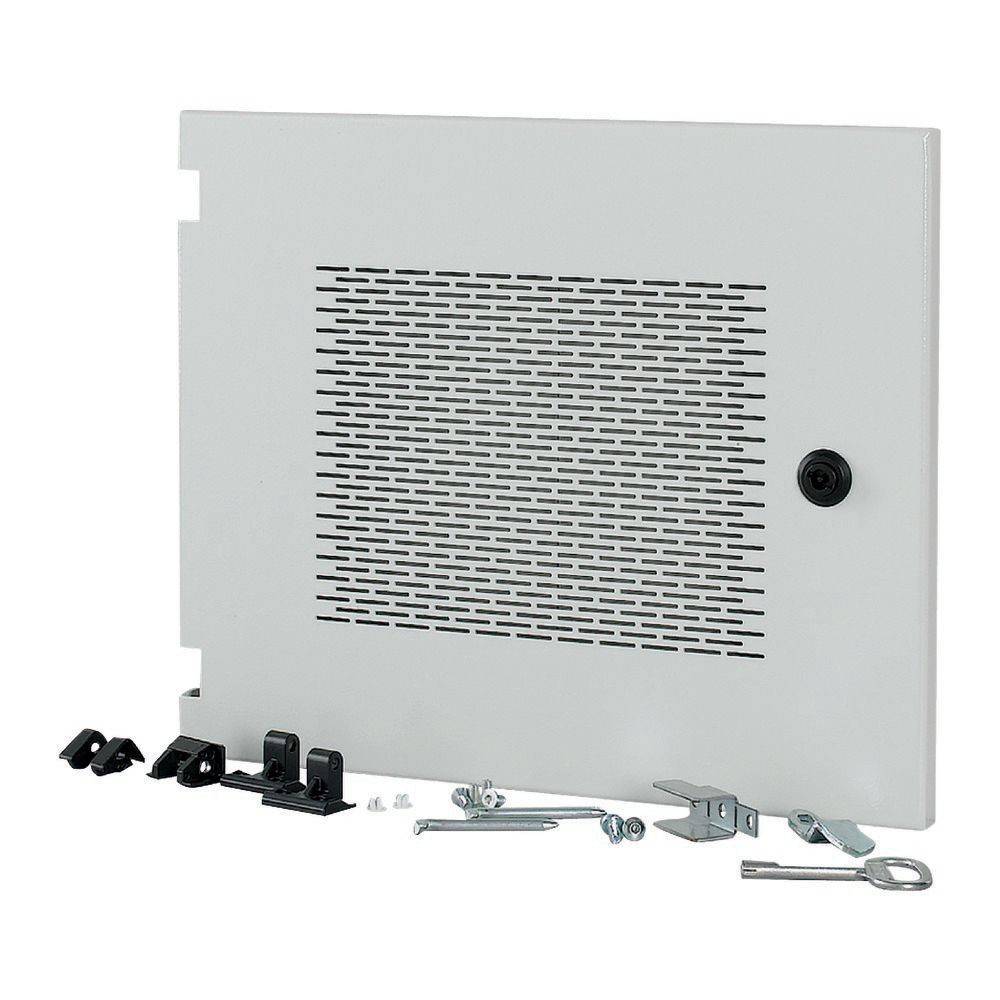 Eine graue Metalltür eines Elektroverteilerkastens mit Lüftungsschlitzen, einem Schlüsselloch und verschiedenen Befestigungshardware-Teilen, die daneben liegen.