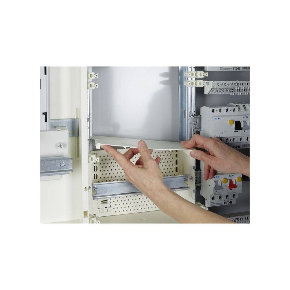 Eine Person justiert eine elektrische Schaltanlage und zeigt Hände, die mit Komponenten, Kabeln und Schaltern interagieren, was Wartungs- oder Installationsarbeiten andeutet.
