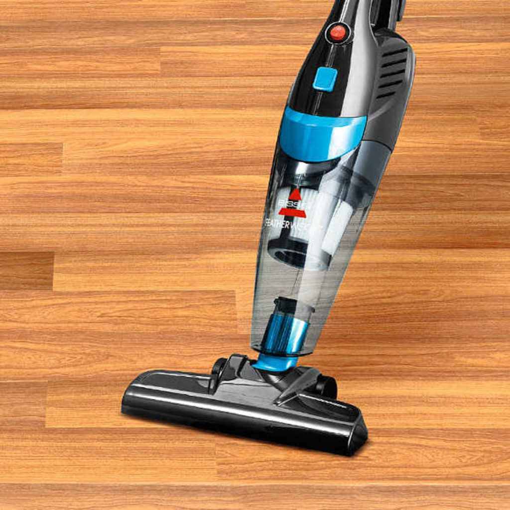 Tragbarer aufrechter Staubsauger reinigt einen Holzboden.