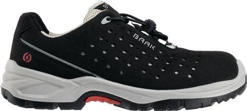 Ein schwarz-weißer Sportschuh mit Perforationen und roten Akzenten, mit dem Markennamen „BAAK