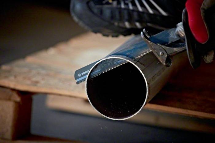 Eine Nahaufnahme eines Kreissägeblatts, das durch ein Stück Holz schneidet, wobei die konzentrierte Schneidaktion hervorgehoben wird, mit sichtbaren Sägespänen.