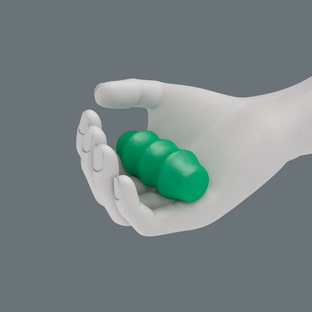 Eine weiße Hand hält einen kleinen, glatten, grünen Gegenstand, der drei miteinander verbundenen Kugeln ähnelt, vor einem einfarbigen grauen Hintergrund.