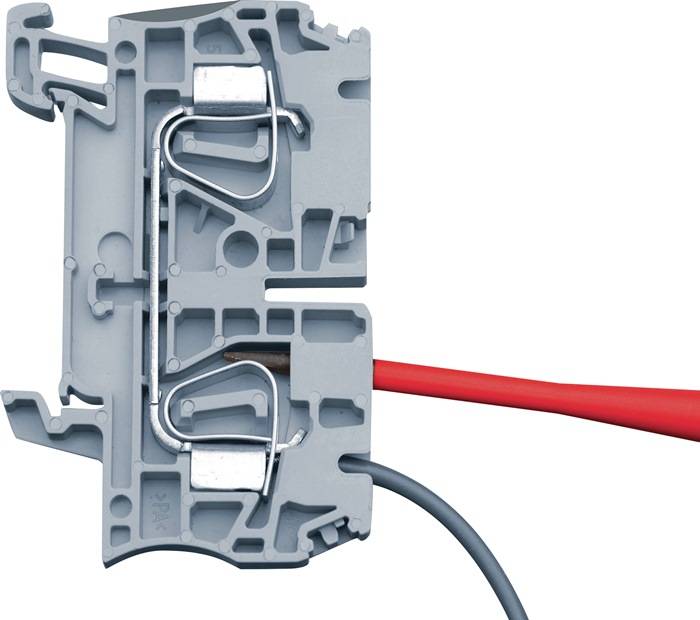Eine Nahaufnahme einer grauen Elektroverteilerdose mit sichtbaren Metallverbindern, in der rote und blaue Kabel von gegenüberliegenden Seiten hineingehen.