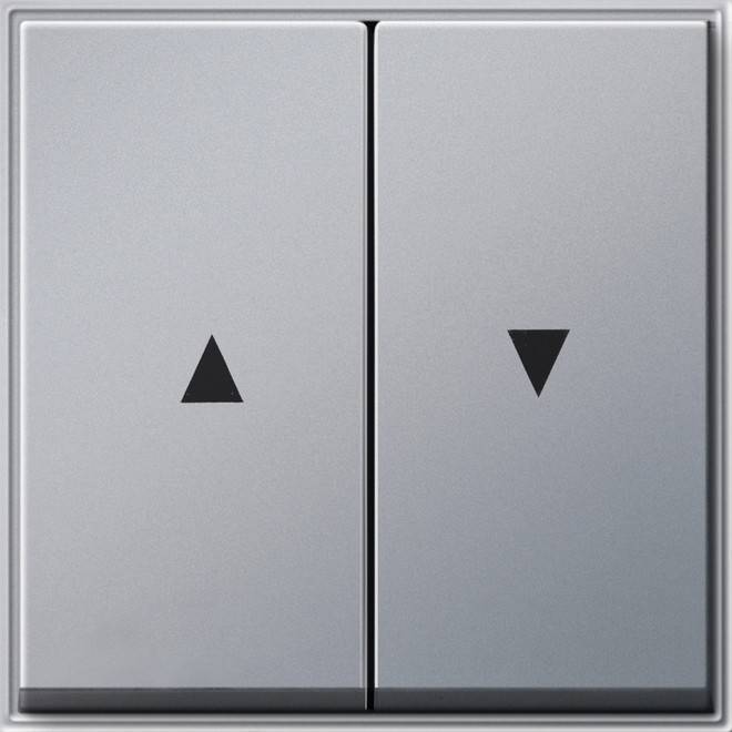 Ein silberner Doppellichtschalter mit Drei- und Abwärtsdreiecksymbolen, die Schalterpositionen oder Funktionen zum Einstellen von Beleuchtung oder Geräten anzeigen.