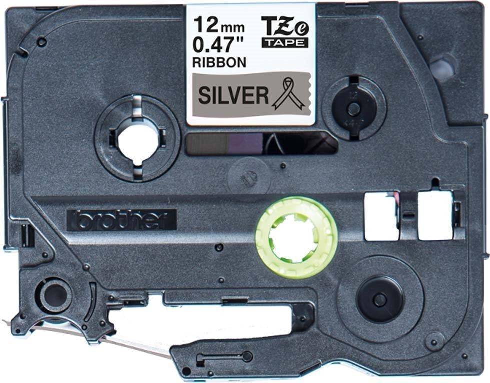 Eine Beschriftungsband-Kassette mit einem '12mm TZe Band in Silberband-Optik'. Schwarzes Plastikgehäuse mit mechanischen Komponenten und sichtbarer Markierung.