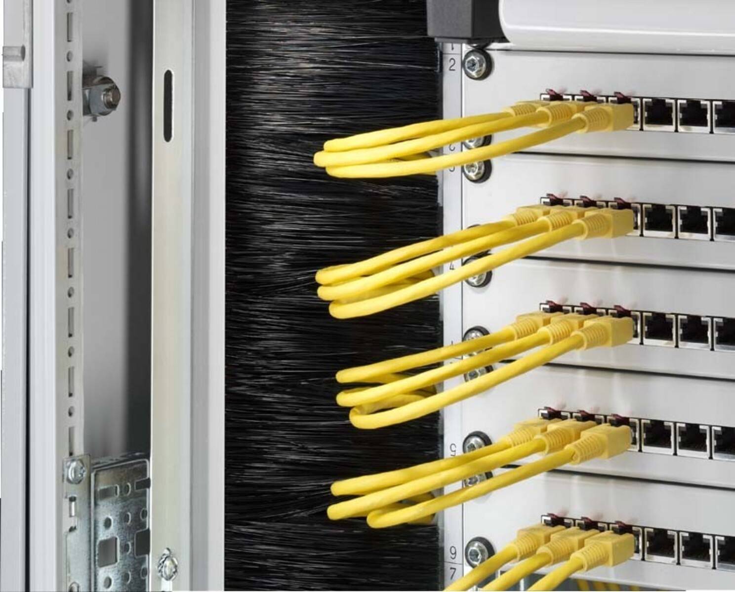 Ein Glasfaser-Patchpanel mit mehreren gelben Kabeln, die angeschlossen sind, wobei jedes Kabel mit Zahlen für die Organisation und einfache Identifizierung beschriftet ist.