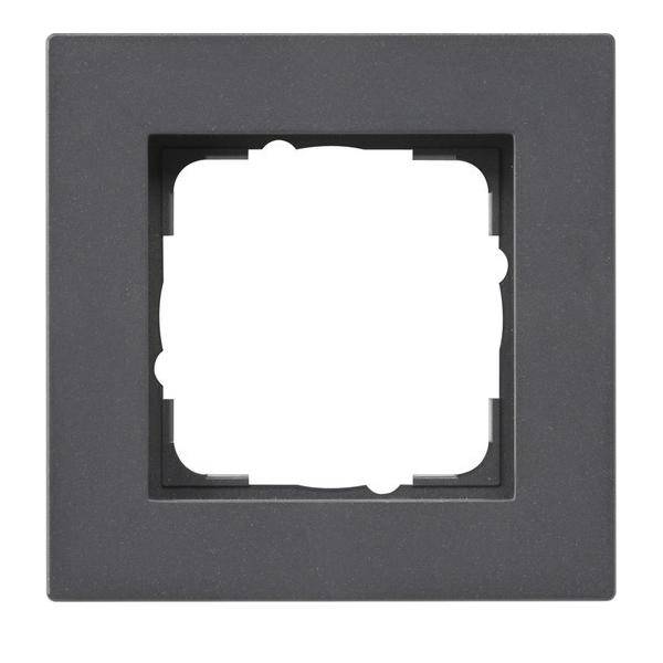 Schwarzer quadratischer Rahmen mit einem zentralen weißen Ausschnitt, möglicherweise zum Einbau eines Lichtschalters oder einer Steckdose. Der Hintergrund ist schlicht weiß.