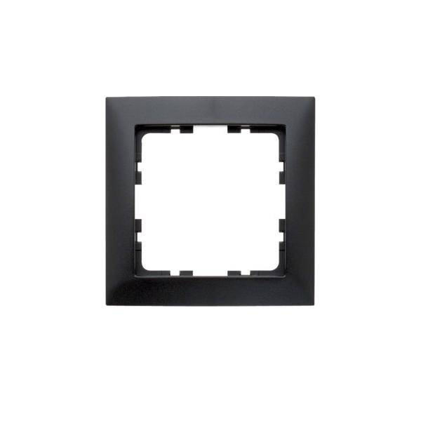 Ein schwarzer quadratischer Elektroauslass-Rahmen mit einer zentralen Aussparung, konzipiert für die Wandmontage, üblicherweise verwendet zur Aufnahme eines Schalters oder einer Steckdose.