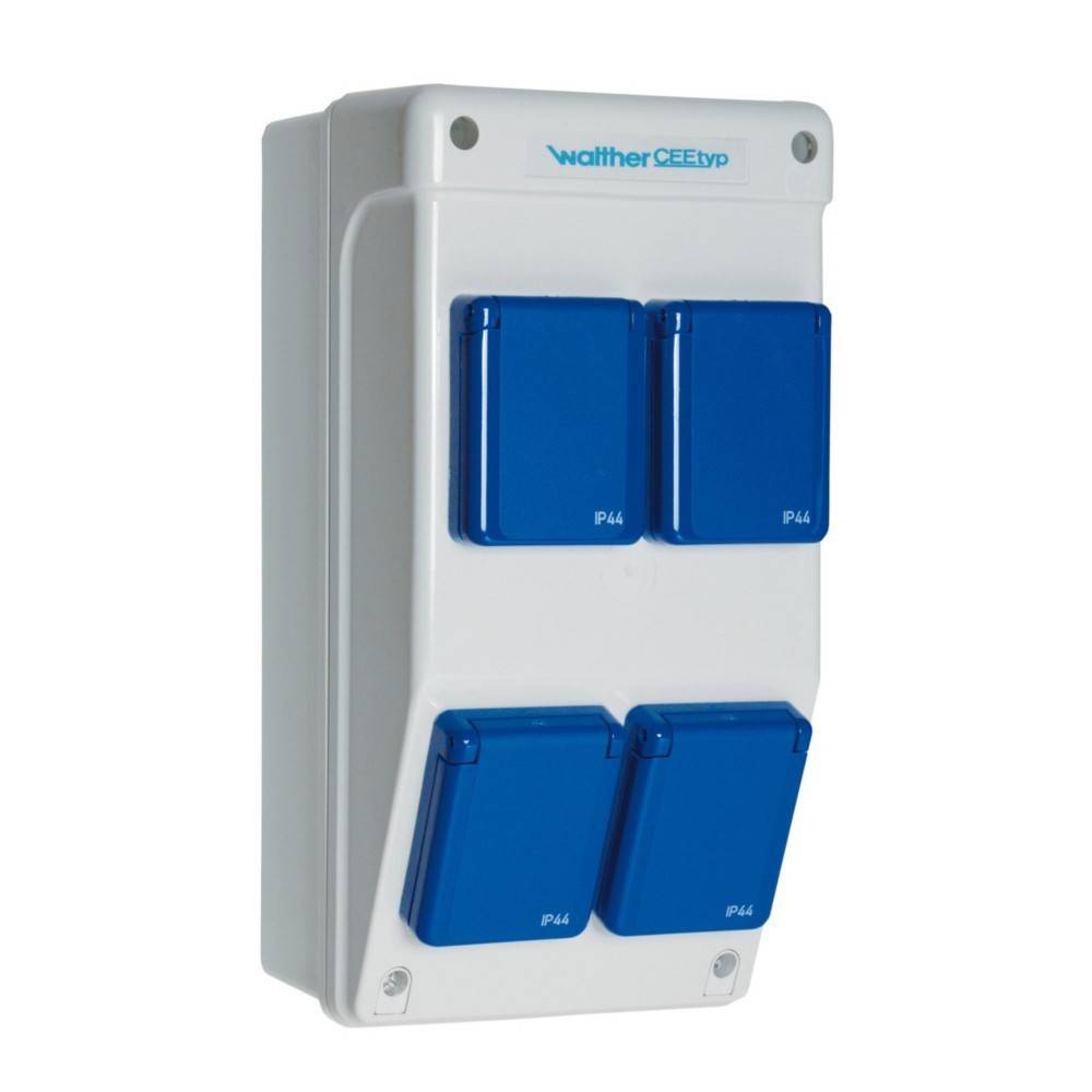 Eine weiße Elektro-Unterputzdose mit vier blauen Steckdosen, mit der Kennzeichnung 'IP44', für den Außenbereich konzipiert, senkrecht montiert.