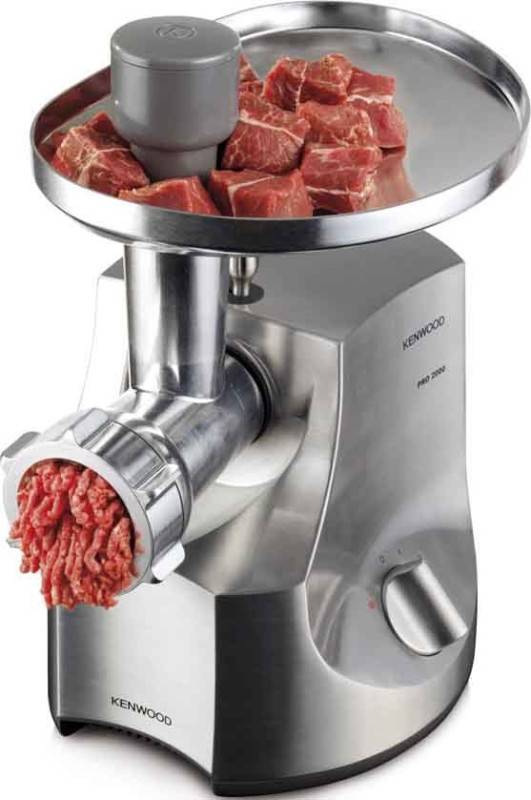 Eine Fleischwolf mit einem runden Tablett hält Fleischstücke oben; gemahlenes Rindfleisch kommt von der vorderen Auslassöffnung der Maschine.