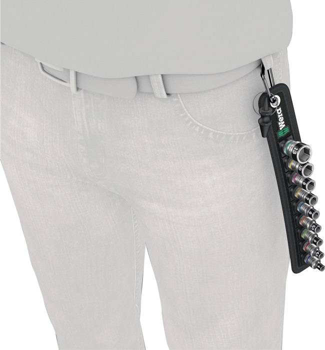 Eine Person mit einer Gürteltasche, an der ein Set aus kleinen, verschiedenen Metallsteckschlüsseln an ihrer rechten Seite befestigt ist.