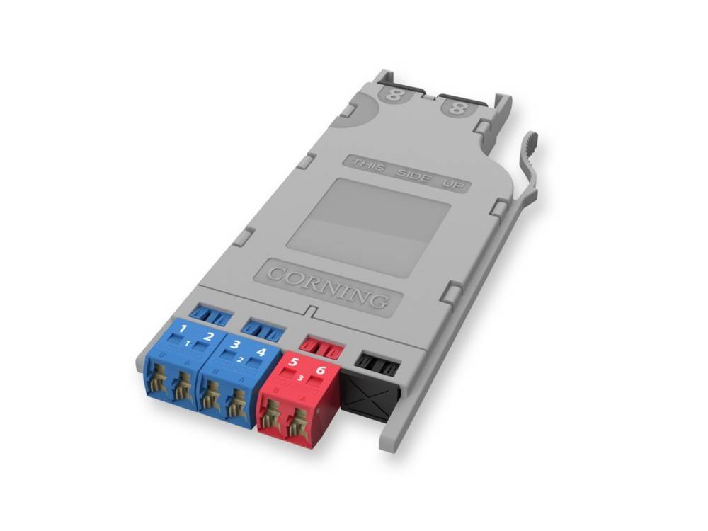 Eine Glasfaserkassette mit sechs beschrifteten Anschlüssen in Blau und Rot. Die Beschriftung zeigt 'CORNING' und gibt die Marke an.