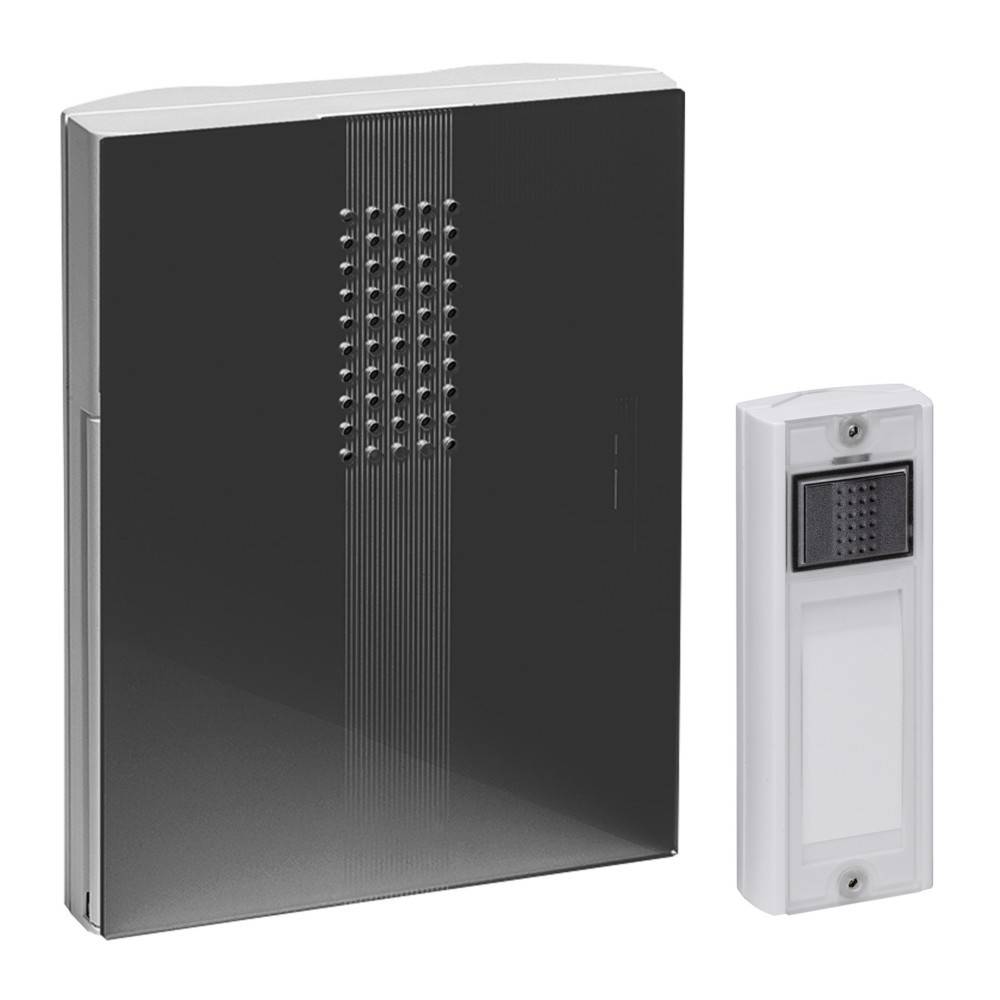 Zwei wandmontierte Geräte: Eine große schwarze rechteckige Einheit mit einem zentralen perforierten Panel und ein kleineres weißes Gegensprechanlage-ähnliches Modul daneben.