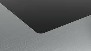 Nahaufnahme einer grau und schwarz geometrischen Oberfläche mit einer geschwungenen schwarzen Vertiefung oben und einer gebürsteten Metalltextur darunter.
