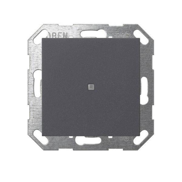 Ein schwarzer quadratischer Lichtschalter mit einer zentralen Taste, montiert in einem silbernen Rahmen mit abgerundeten Ecken.