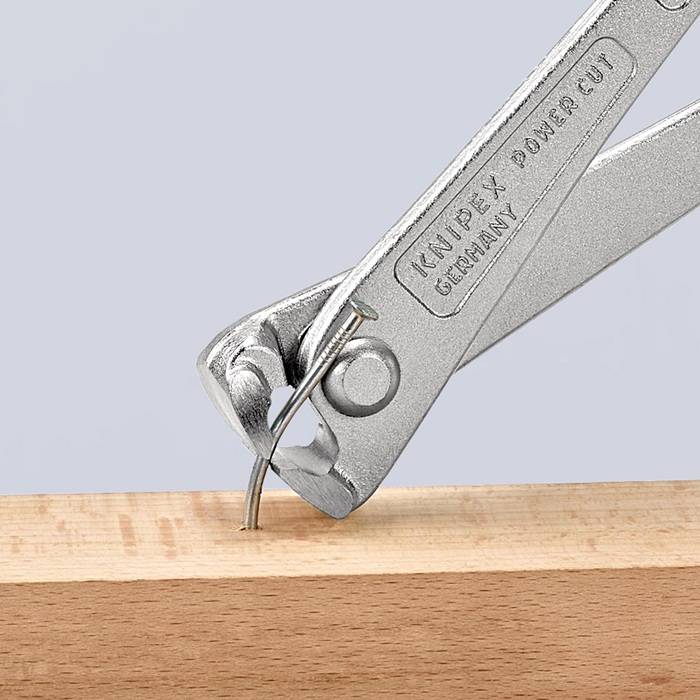 Ein metallisches Multitool mit einer Nagelzieher-Funktion zieht einen Nagel aus einer Holzoberfläche. Das Werkzeug ist mit 