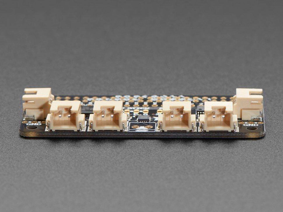 Eine schwarze Leiterplatte mit mehreren beigen Anschlüssen, die in einer Reihe ausgerichtet sind und für elektronische Projekte und Prototyping entwickelt wurde.