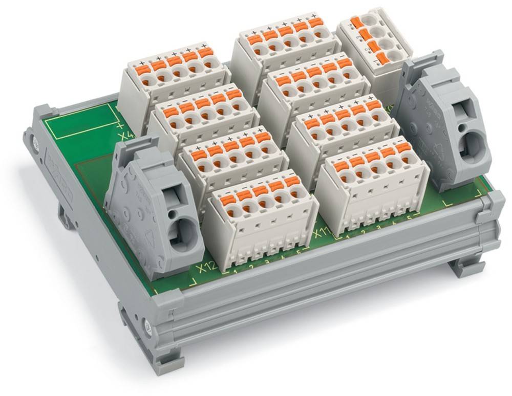 Ein Terminalblock mit mehreren Anschlussporten in Reihen auf einer grünen Tafel, der für elektrische Verbindungen in industriellen Umgebungen verwendet wird.